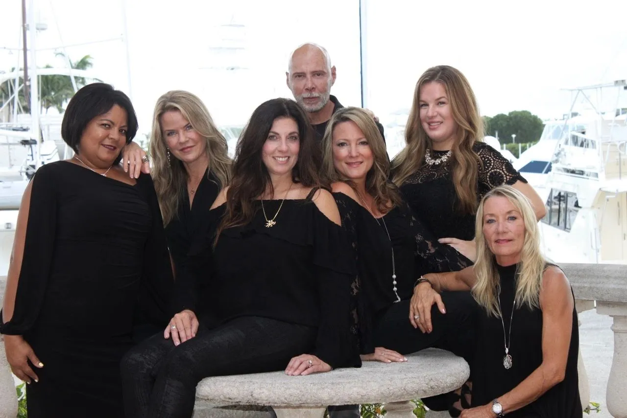 The Salon Aquatica team in black, gathered on the terrace above the PGA Marina